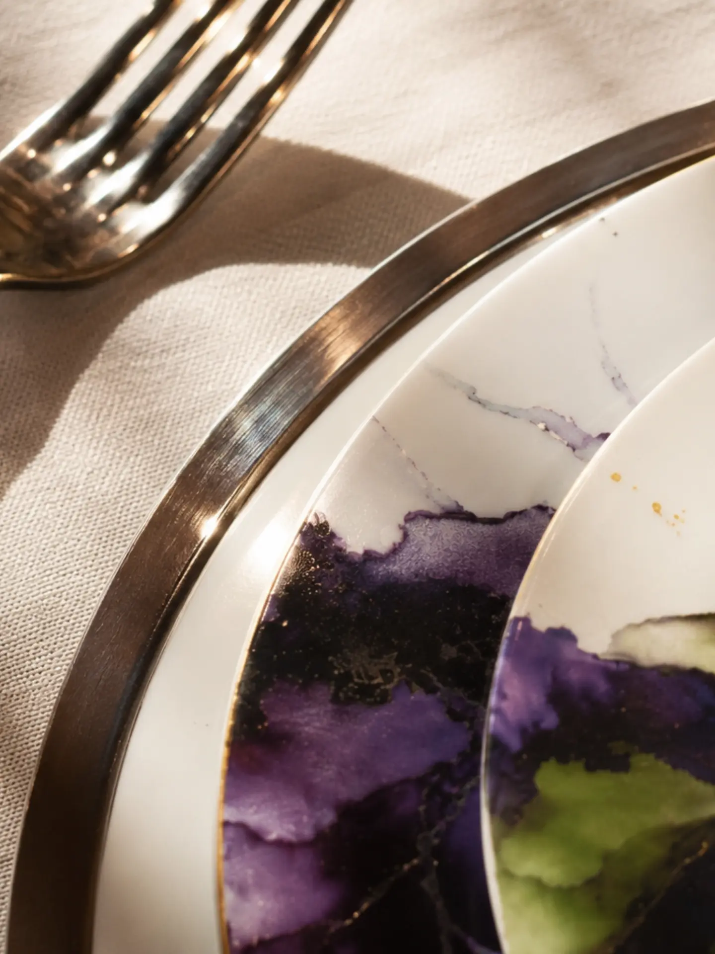 Detalhe da pintura aquarelada roxa e verde na borda da porcelana Casa Salvatti