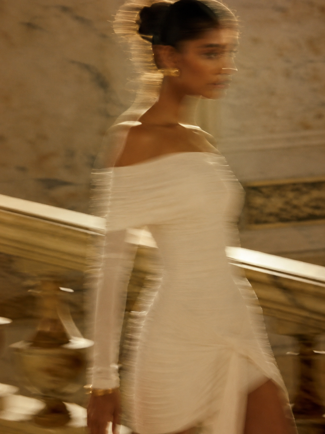 Modelo de vestido branco em movimento sob a luz dourada