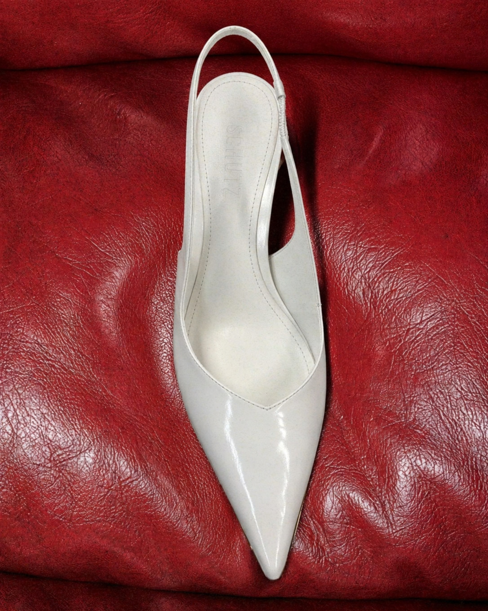 Scarpin branco SCHUTZ sobre couro vermelho
