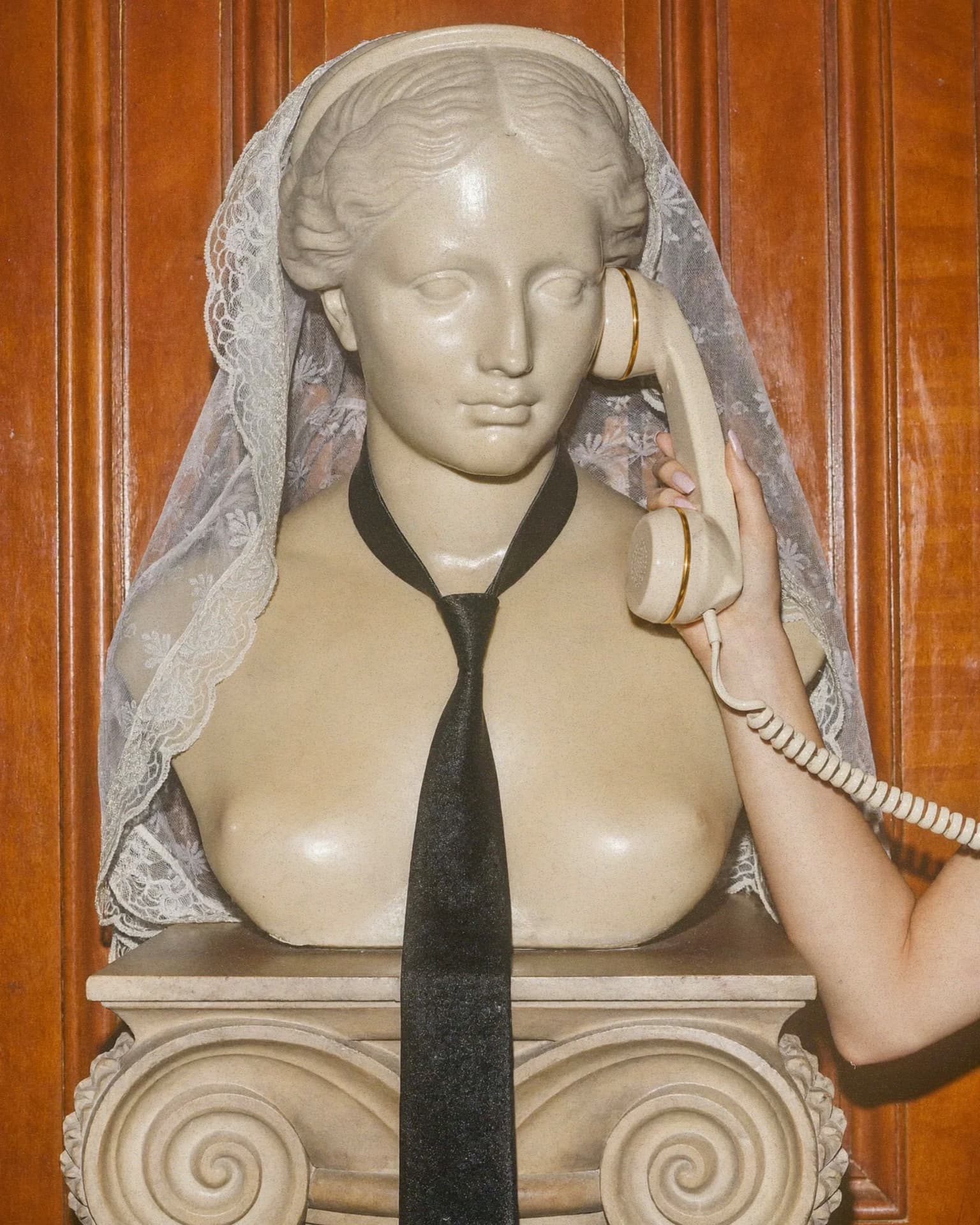 Busto com véu de noiva e telefone retrô em cena editorial