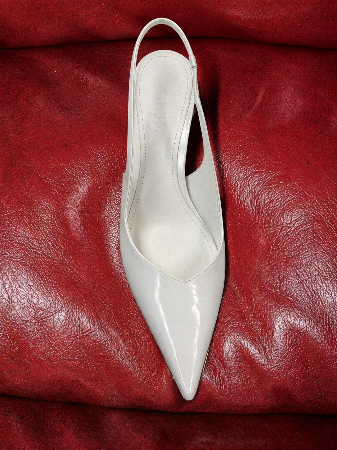 Scarpin branco SCHUTZ sobre couro vermelho